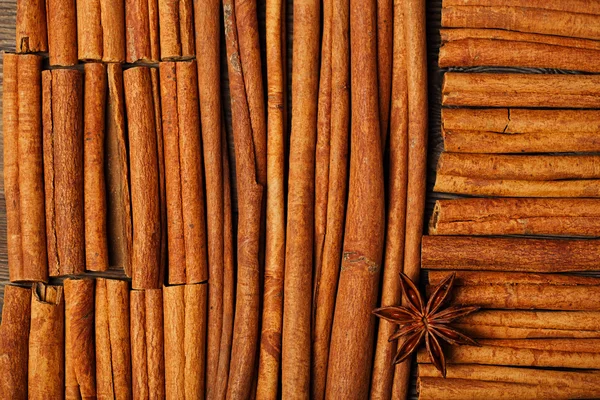 Cinnamon sticks and anise star on wooden background