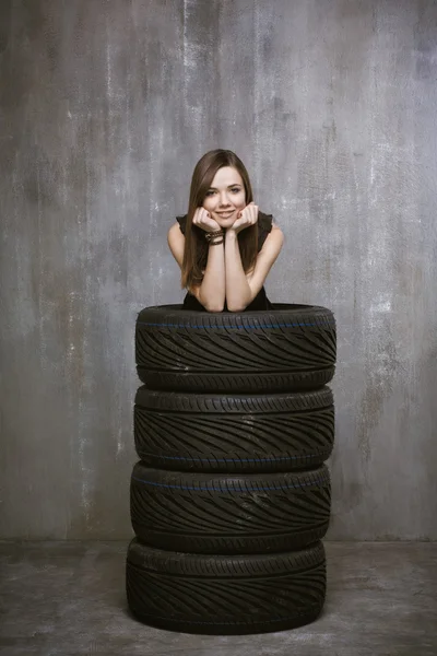 Portrait of a young girl who is inside automobile tires, on the