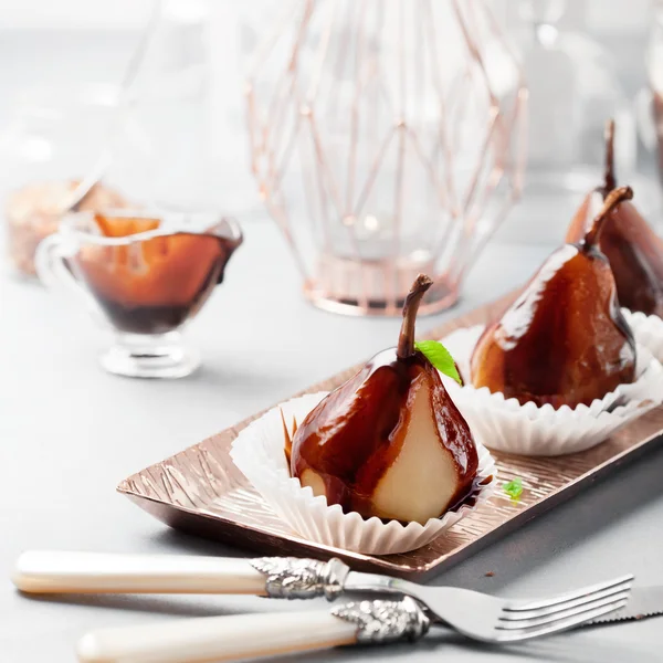 Pears in dark chocolate, sweet dessert, closeup shot