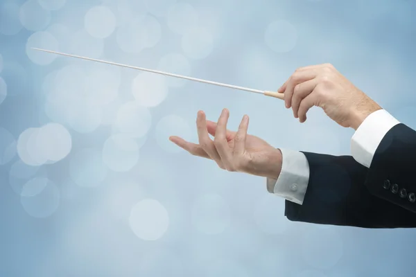 Orchestra conductor hands with baton