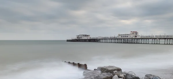 Beautiful long exposure sunset landscape image of pier at sea in