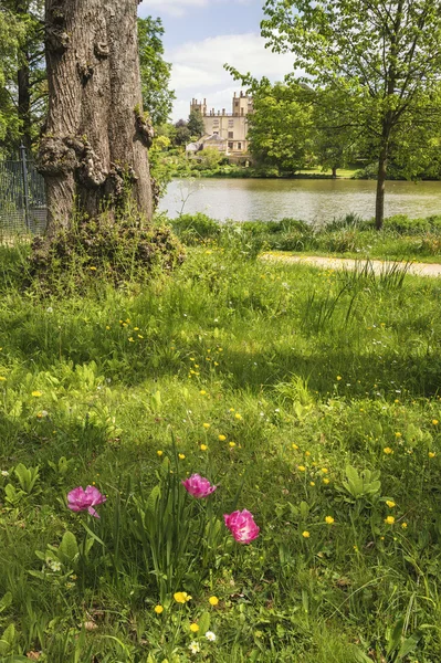 Landscape image of old Victorian house viewed across lake on Sum