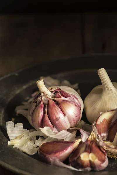 Fresh garlic cloves in moody natural lighting set up with vintag