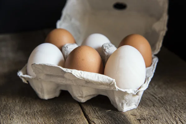 Fresh eggs in egg box in moody natural lighting vintage retro st