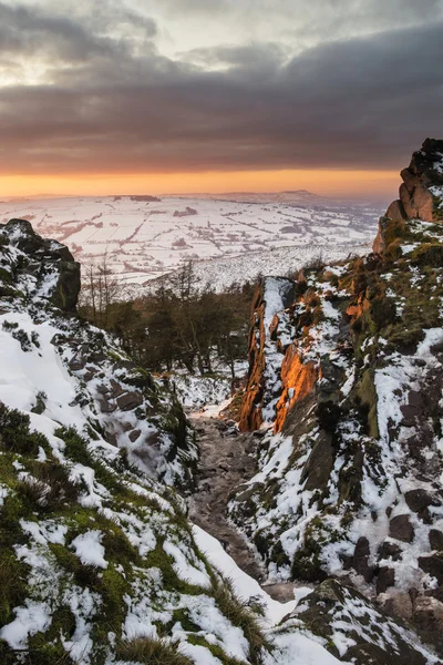 Stunning Winter sunset landscape from mountains looking over sno