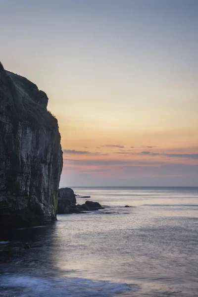 Stunning coastal landscape with long exposure waves crashing at