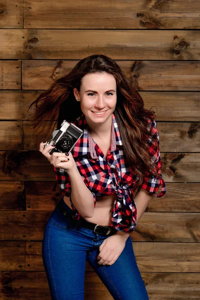 Young women posing in studio with old camera