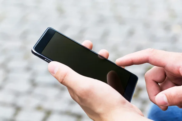 Man using his Mobile Phone outdoor, close up