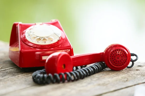 Red phone on wooden deck