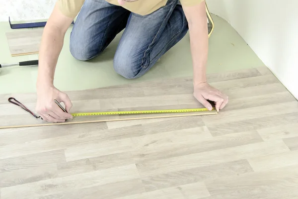 Man with Tools to Laying Laminate