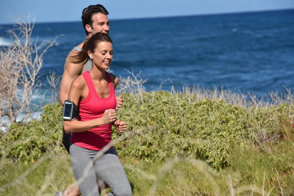 Joggers running by the sea