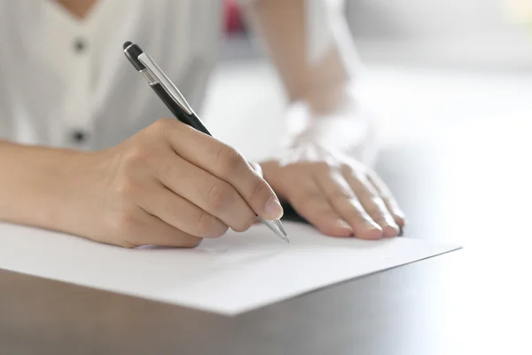 Woman's hand writing on paper