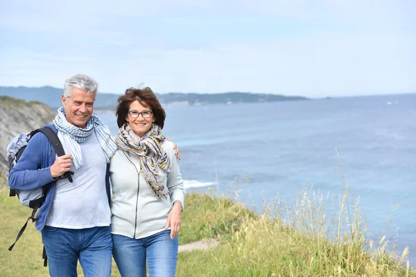 couple walking by sea cliff