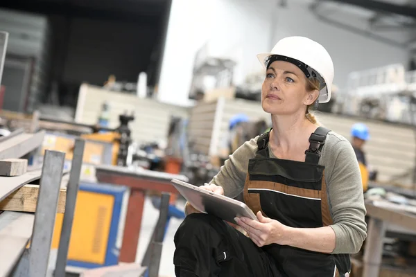 Woman in warehouse checking production