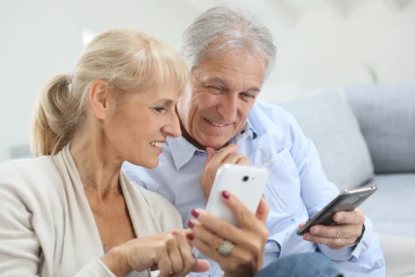 Couple at home using smartphone