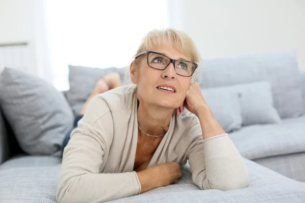 Smiling woman laying on couch