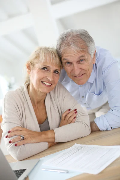 Couple at home filling pension paper
