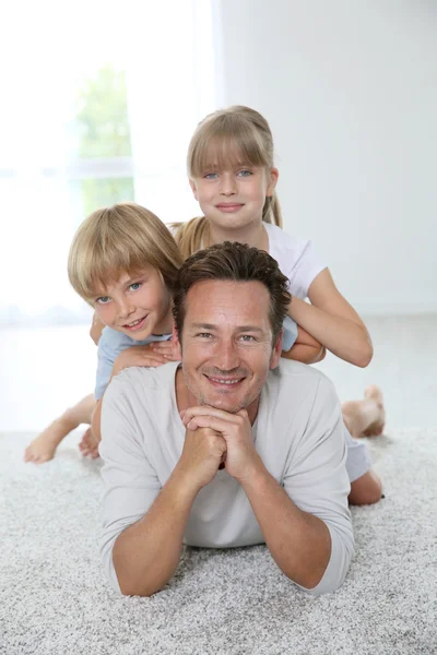 Daddy with kids laying on carpet