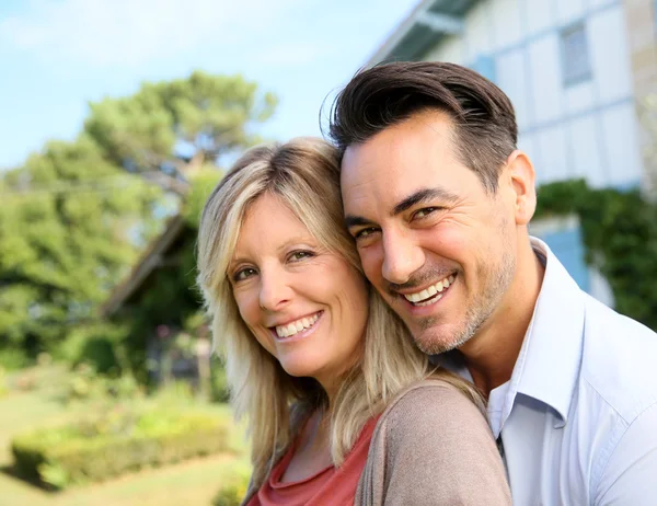 Mature couple in front of house