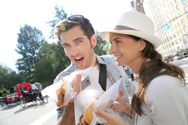 Tourists in New York eating hot dogs