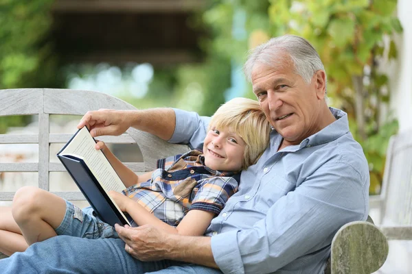 Grandfather reading book with grandson