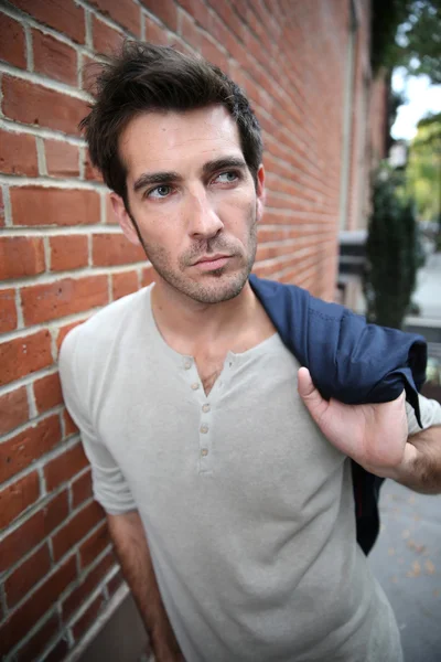 Man leaning on wall in street