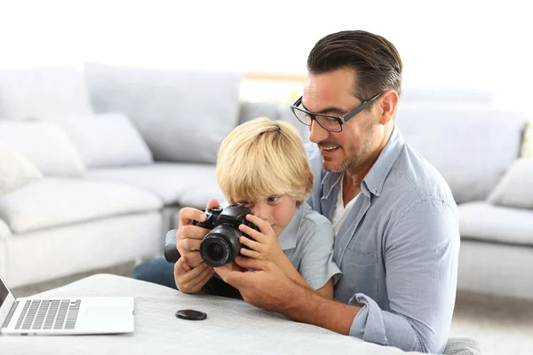 Man with boy playing with reflex camera
