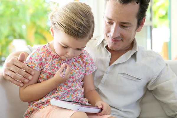 Man with daughter playing with tablet