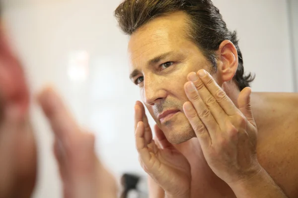 Man applying facial lotion