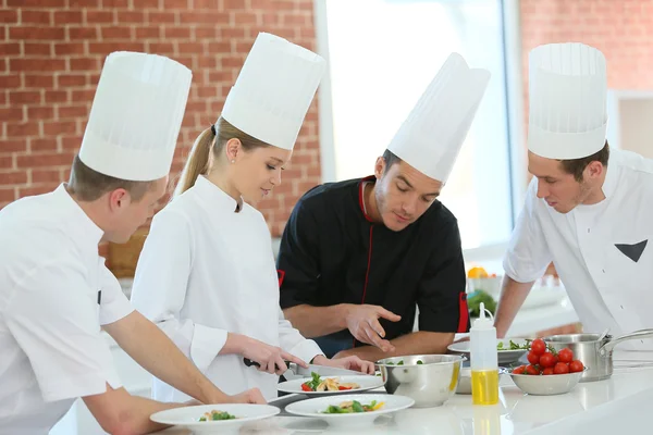 Chef training students in kitchen