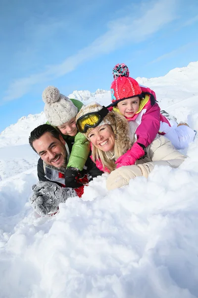 Family laying down in snow