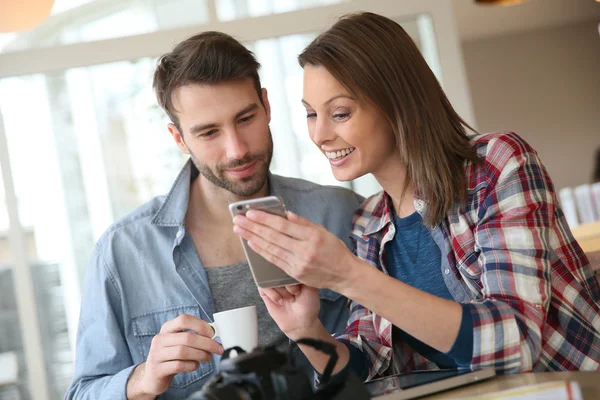 Couple looking at pictures on smartphone