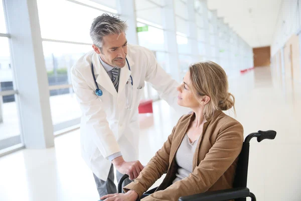 Doctor talking to woman in wheelchair