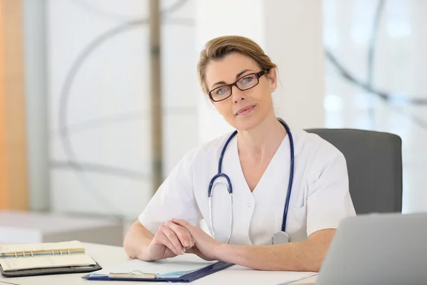 Mature nurse in office