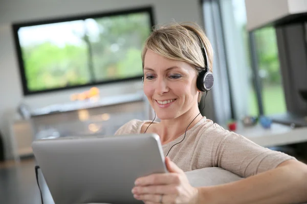 Woman connected on tablet and wearing headset