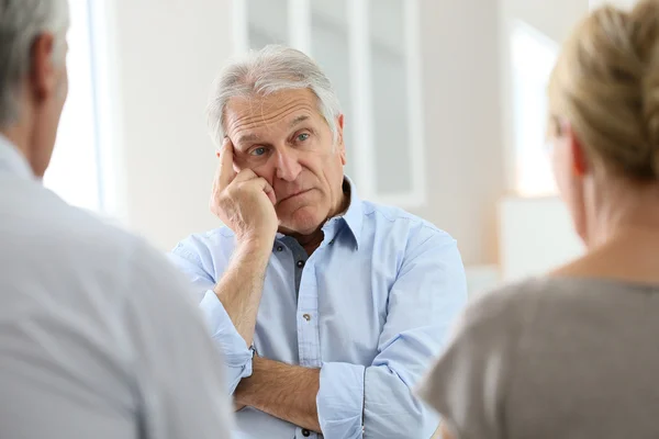 Man attending meeting with group therapist