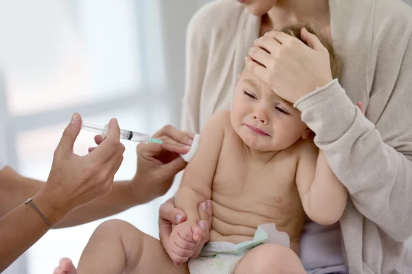 Baby girl  receiving vaccine injection