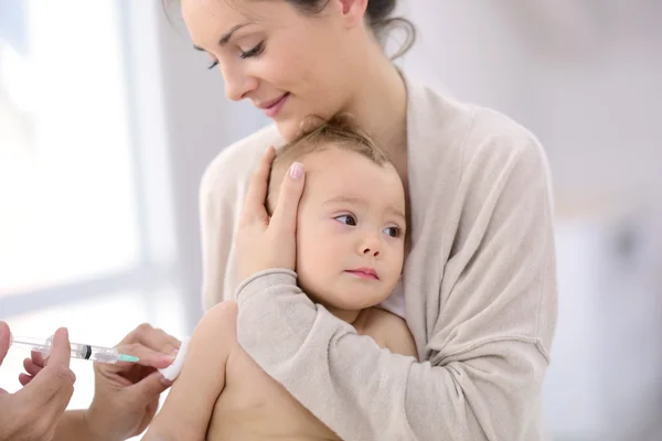 Baby girl receiving vaccine injection