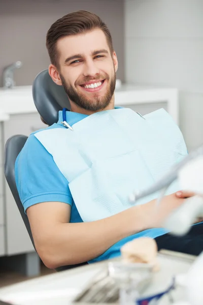 Portrait of happy patient in dental chair.