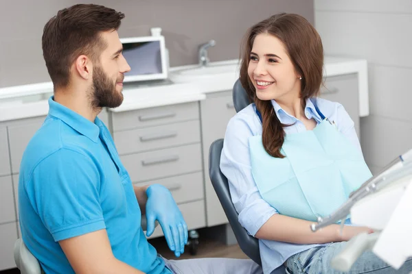 Portrait of a male dentist and young happy  female patient.