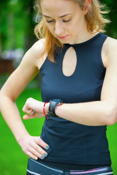 Female runner looking at her sport watch.