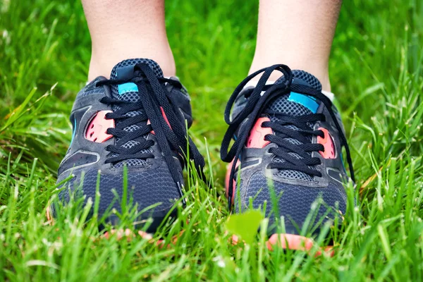 Close up of running shoes on grass.