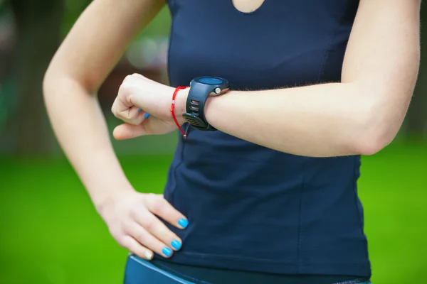 Female runner looking at her sport watch.