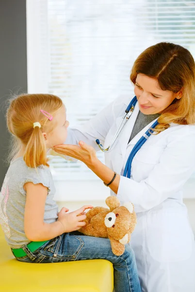 Pediatrician taking temperature with thermometer.