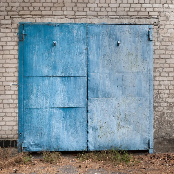 Old weathered blue garage doors.