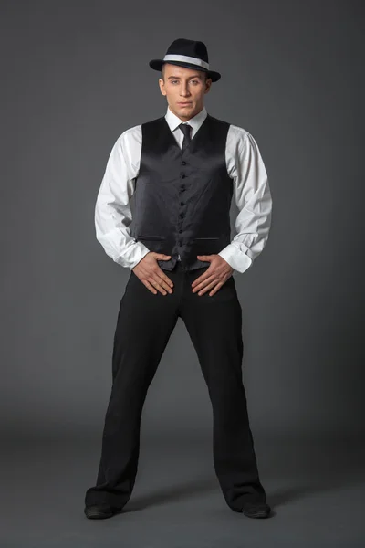Young male confident male posing in gangster style suite.