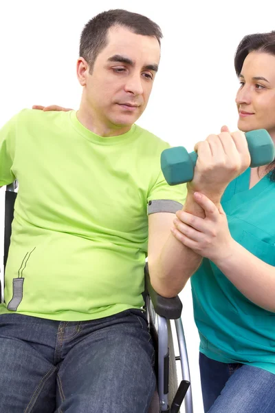 Physical therapist works with patient in lifting hands weights.
