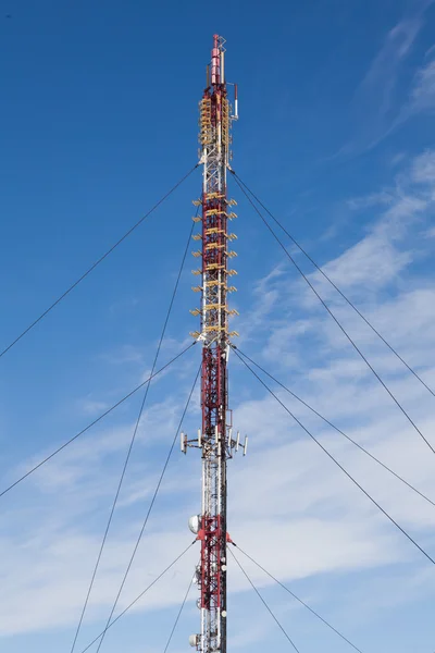 Radio equipment on high iron mast. Blue sky.