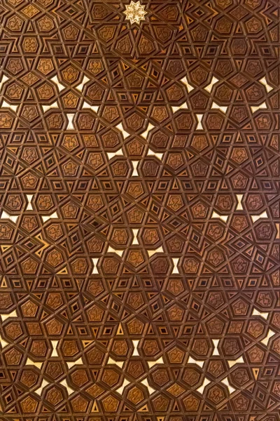 Islamic geometric stars motif pattern, carved on the surface of an old wooden door.