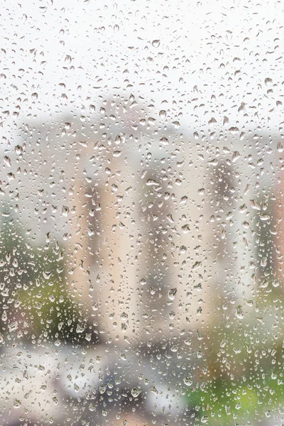 View of raindrops on window of apartment house